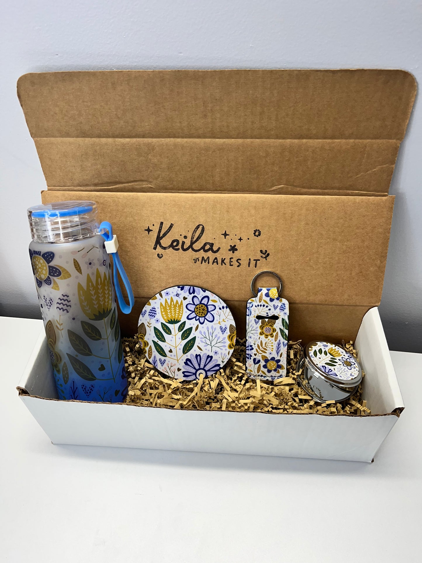 Blue flowers bundle gift box. Includes a frosted glass bottle 16 oz, coaster, keychain lipstick holder and portable mirror